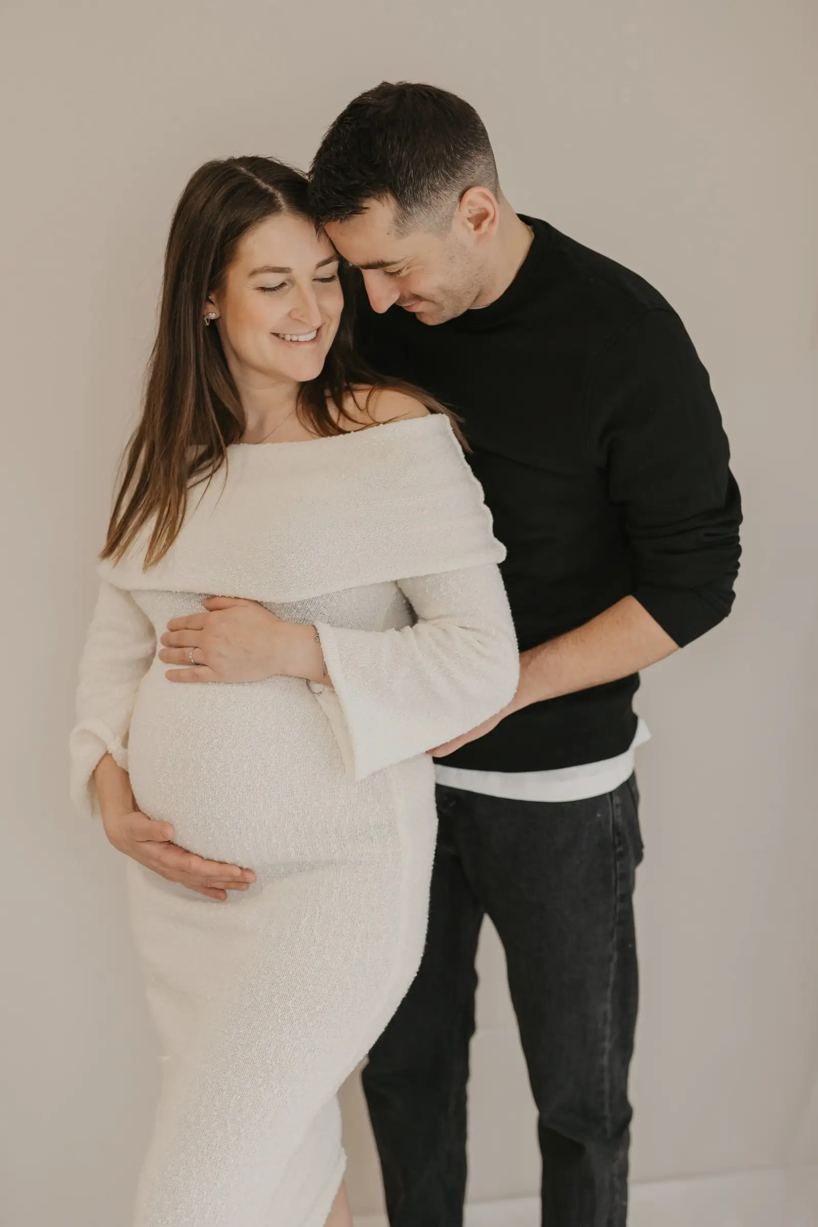 Paar im hellen Strickkleid, der Partner umarmt sie
