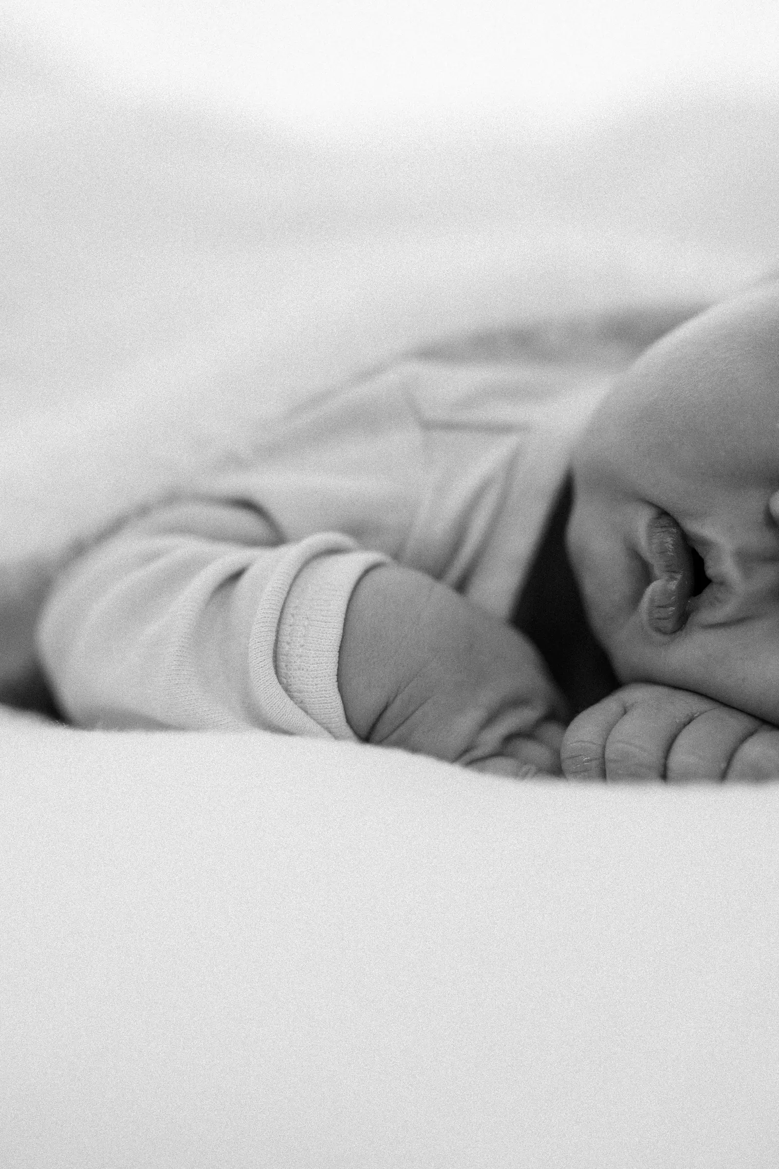 Schwarz-weiß-Detail: kleine Füße unter einer Decke