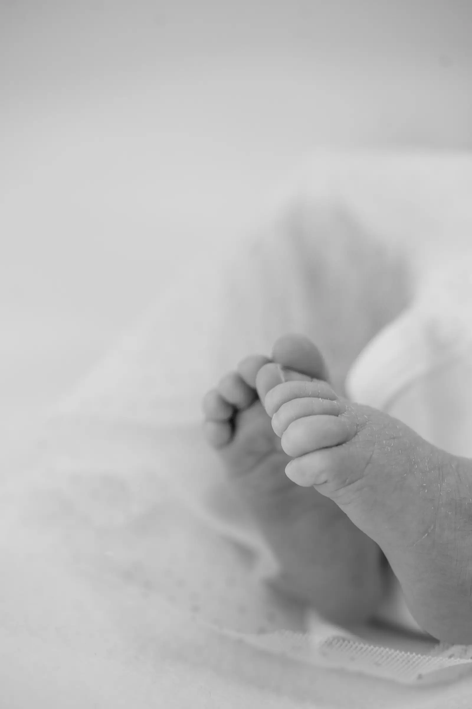 Schwarz-weiß-Detail: Babyfüße auf einer Decke